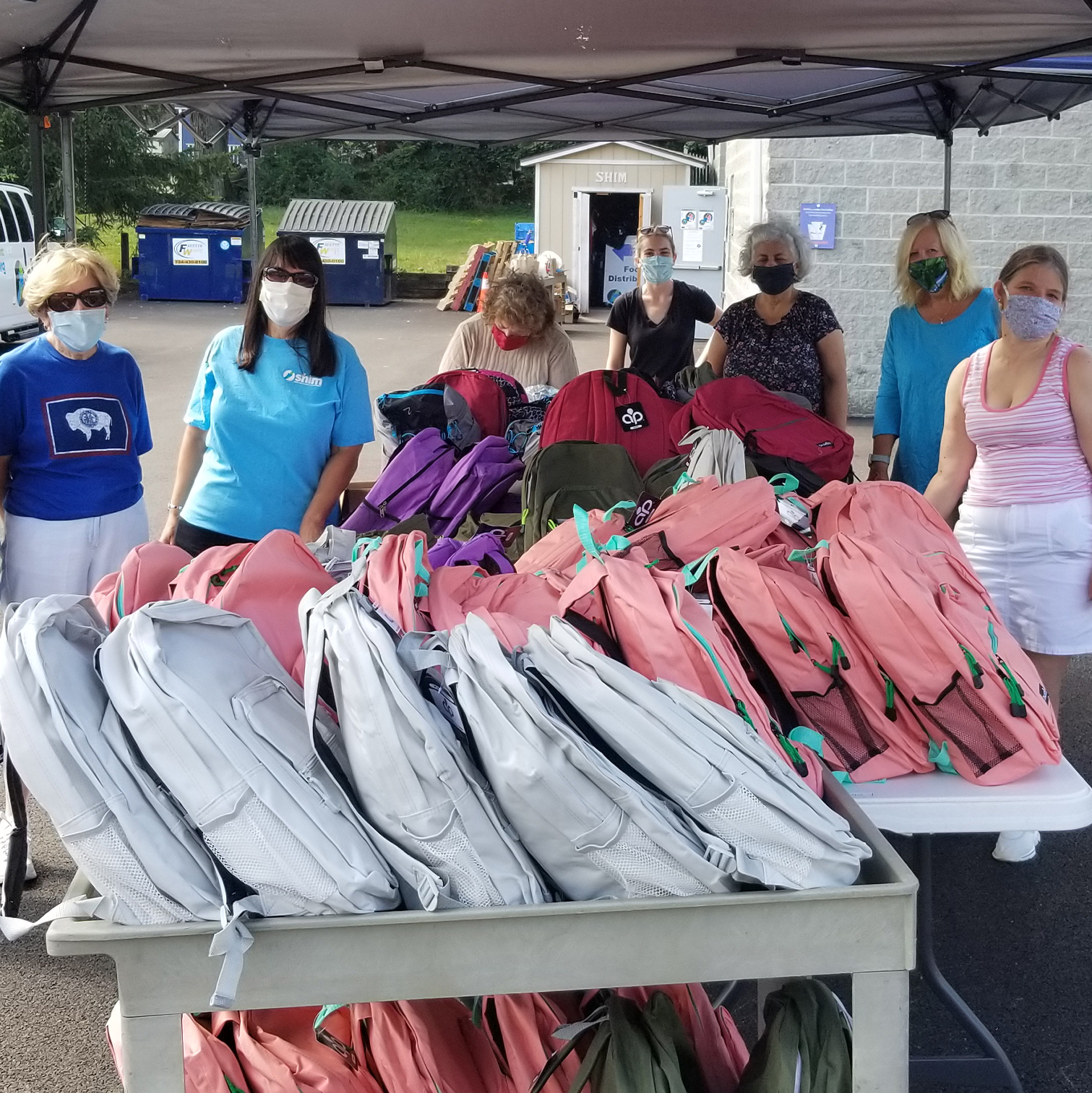 trib-bb-distr Group of volunteers with book bag donations